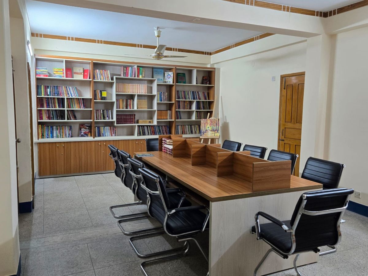 Study tables with desk dividers in front of the library bookshelves